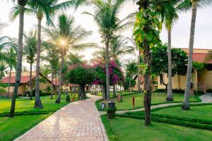 a park with palm trees and a brick walkway at Pandanus Resort in Mui Ne
