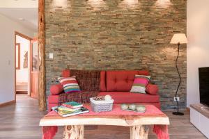 ein Wohnzimmer mit einem roten Sofa und einem Tisch in der Unterkunft HEAVEN CATEDRAL in San Carlos de Bariloche