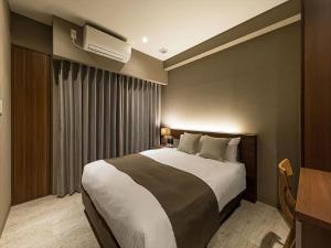 HOTEL SHINPOIN OSAKA tesisinde bir odada yatak veya yataklar