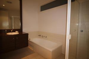 a bathroom with a bath tub and a sink at Breakers Holiday House in Lorne +19 photos