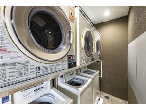 two washing machines and a washer and dryer in a room at HOTEL SHINPOIN OSAKA in Osaka