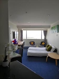 um quarto de hotel com duas camas e uma mesa e cadeiras em Picture Perfect Hotel Living em Auckland