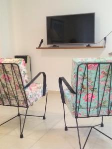2 sillas en una habitación con TV en la pared en Famiglia Dtos en San Rafael