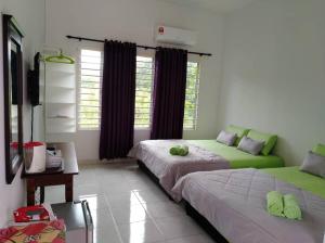 a bedroom with two beds and a couch in it at D' Surya Lavender Inn in Pantai Cenang
