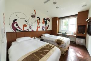 a hotel room with two beds and a mural on the wall at Shante Hotel Shitou in Lugu +38 photos