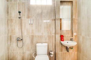 een badkamer met een douche, een toilet en een wastafel bij RedDoorz Plus near Lempuyangan Station 4 in Yogyakarta