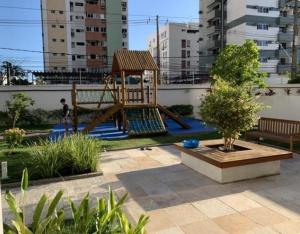 a playground with a swing set in a garden at Riviera CONDOMINIO Clube - BOA VIAGEM torre natura ap 1103 in Recife