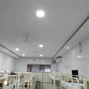 Habitación hospitalaria con sillas blancas y techo blanco en Star Dormitory, en Bombay