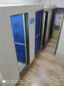 a row of glass doors in a room with a wooden floor at Star Dormitory in Mumbai