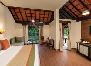 a bedroom with a bed and a living room at RVR Sarovar Portico in Rāzole