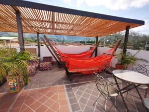 a patio with two hammocks and a table and chairs at Apolonia Boutique in Guaduas