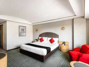 une chambre d'hôtel avec un lit et un canapé rouge dans l'établissement Capital O Andrade, Mexico City, à Mexico