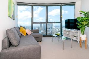 a living room with a couch and a television at Lvl 59 Skytower Amazing Views CBD Wifi Carpark by Stylish Stays in Brisbane