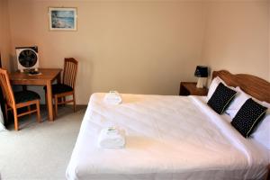 Schlafzimmer mit einem Bett, einem Schreibtisch und einem Tisch in der Unterkunft Owen River Tavern & Motels in Owen River