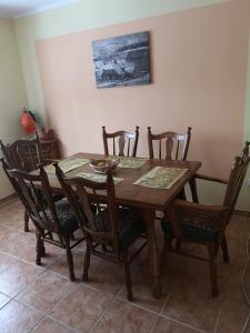 a dining room table with six chairs and a table and a painting at Leśniczówka in Jelenia Góra-Jagniątków