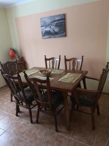 a dining room table with six chairs and a table and a painting at Leśniczówka in Jagniątków