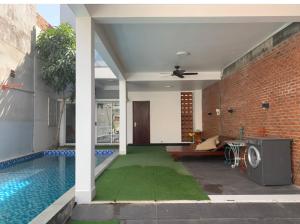 a house with a swimming pool and a brick wall at Pho Bien Homestay in Phan Thiet