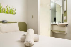 a bedroom with a bed with a towel on it at ibis budget Manchester Salford Quays in Manchester