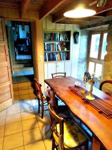 uma sala de jantar com uma mesa de madeira e cadeiras em au petit bonheur em Putanges