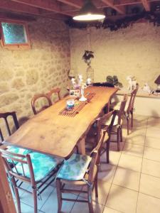 a dining room with a wooden table and chairs at au petit bonheur in Putanges +6 photos