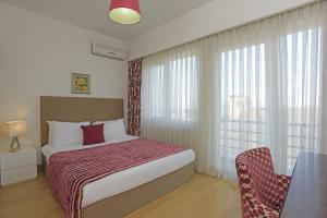 a bedroom with a bed and a table and a window at Cheya Residence Gumussuyu in Istanbul