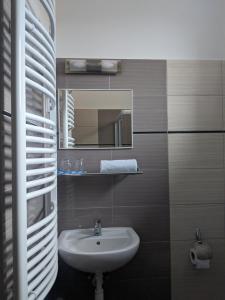 een badkamer met een wastafel en een spiegel bij Római Fürdő Apartmanház in Bakonynána