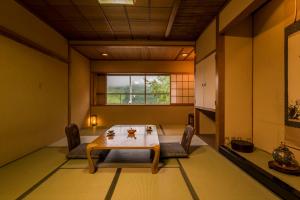 a dining room with a table and chairs and a window at Takamiya Hotel Jurin in Zao Onsen