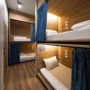 a room with three bunk beds and a bed in it at Natee Hostel in Bangkok