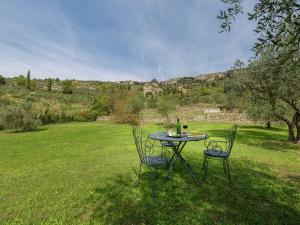 einen Tisch und zwei Stühle auf einem Feld in der Unterkunft Belvilla by OYO Fontocchio in Cortona