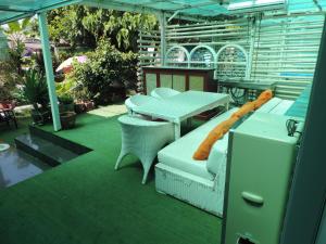 patio con tavolo e sedie su un tappeto verde di Blue Paradise Residence a Rawai Beach