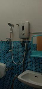 y baño con lavabo, espejo y ducha. en Baiti Homestay, en Gambang
