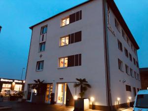 a white building with palm trees in front of it at Hotel Glinde in Hamburg