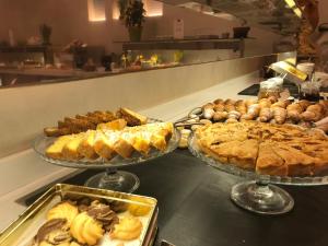 een buffet met drie schotels taarten en gebak bij Hotel Monte Rosa in Chiavari