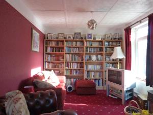 a living room with bookshelves filled with books at Millbrook in Helston