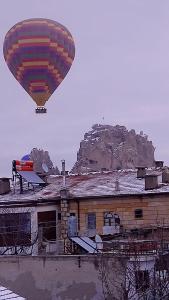 una mongolfiera sta volando sopra un edificio di Capiedra Hotel a Üçhisar