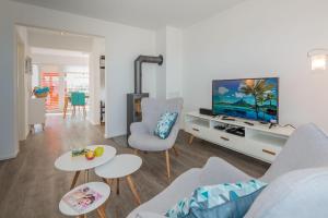 a living room with a couch and a tv at Drachenfisch in Olpenitz