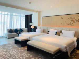 Habitación de hotel con 2 camas y sofá en Rainbird Hotel en Chengdú