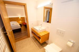 a bathroom with a sink and a mirror and a bed at Finest Villa Zell am See by All in One Apartments in Zell am See