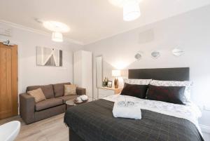 a bedroom with a large bed and a couch at 11 Helena House Business Apartment in Reading