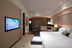 a hotel room with a large bed and a living room at Rainbird Hotel in Chengdu