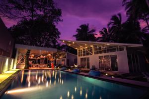 a swimming pool in front of a house at night at Mawella Beach Resort in Tangalle