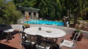 a patio with a table and chairs and a pool at Bloom Guest House in Cape Town