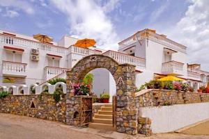 a building with a stone wall and an arch at Seva' s Studios in Livadia