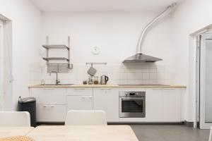 a kitchen with white appliances and a table and chairs at Dom gościnny Luk Luk in Sopot