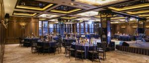 a room full of tables and chairs with wine bottles on them at Chinggis Khaan Hotel in Ulaanbaatar