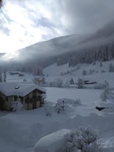 a house covered in snow in front of a mountain at Haus Fürhapter Markus in Innervillgraten