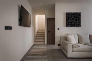 a living room with a couch and a television at Bianco Villa - Adam in Pefki