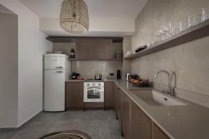 a kitchen with a white refrigerator and a sink at Bianco Villa - Adam in Pefki