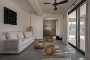 a living room with a white couch and a ceiling fan at Bianco Villa - Adam in Pefki