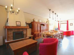een woonkamer met een open haard en een tafel en stoelen bij Welcoming Mansion with Sauna in Herbeumont in Herbeumont